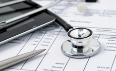 fanned out medical bills with a stethoscope on top