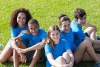 Group of teens sitting on grass.