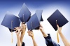 five black graduation caps held in the air