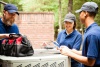 Air conditionaing technicians working around an air conditioner