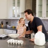 Dad and daughter cooking together in kitchen.