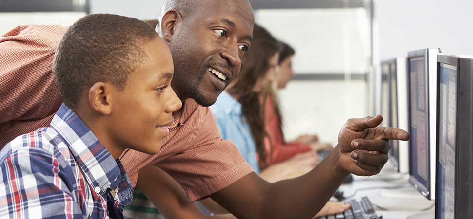 Teacher showing student an example on a computer screen